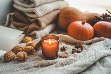 Obraz na płótnie Canvas Burning candle in a cozy autumn interior