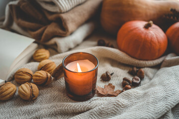 Fototapeta na wymiar Burning candle in a cozy autumn interior