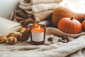 Obraz na płótnie Canvas Burning candle with label isolated in autumn interior