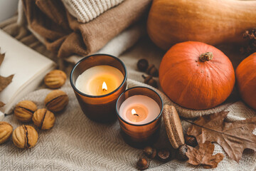 Obraz na płótnie Canvas Two burning candles in the autumn interior