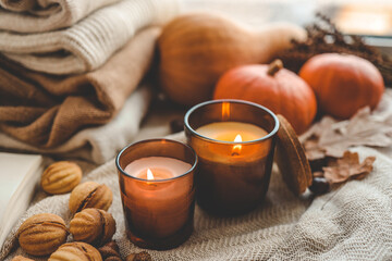 Two burning candles in the autumn interior