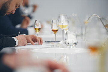 Blind tasting, close up. Sommelier makes notes on the tasting card. 