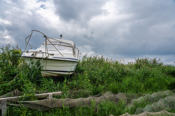 A old boat in the harbour from Lodding  in the tall reeds in front of it are traps