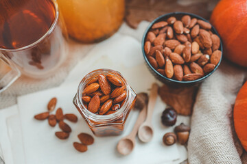Jar with craft sweet honey and nuts in autumn interior