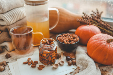 Fototapeta premium Jar with craft sweet honey and nuts in autumn interior