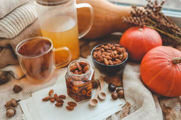 Jar with craft sweet honey and nuts in autumn interior