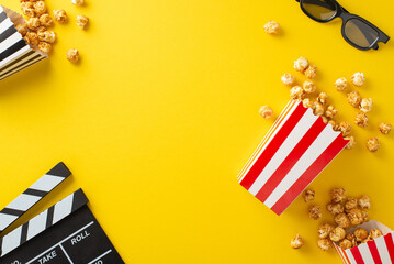 Cinematograph-inspired arrangement: Top-down view image of patterned cases containing popcorn, 3D glasses, and a clapperboard. Resting on yellow background with empty area for text or advertisement