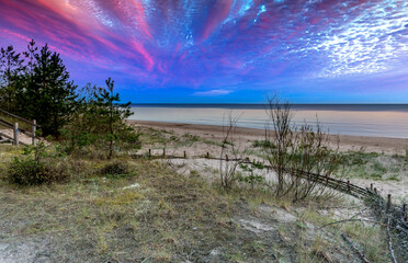 Coastal landscape with sandy beach of the Baltic Sea during colorful sunrise
