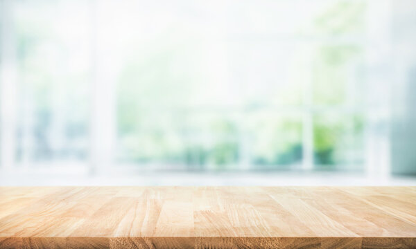 Selective focus.Empty of wood table top on blur of curtain with window and green from garden background.For montage product display or design key visual layout