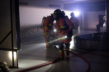Firefighters are working in the airport at night. With the fire situation from terrorism
