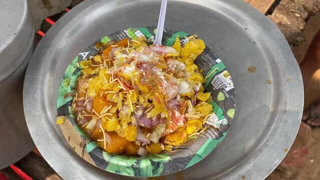 Close up shot of aloo tikki chaat, a mouth watering Indian snack been served at a roadside food stall at daytime.