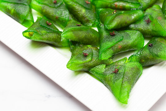 Close-up of Indian sweet "Paan petha" on a white ceramic plate.