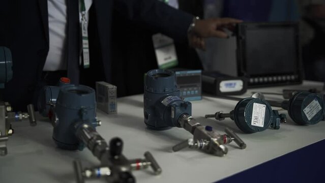 Engineer adjusts pressure sensors on display taking part in industrial exhibition closeup. Indication equipment for safety control