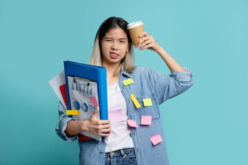 Bored Asian female office worker with a lot of work with holding document file  with cup of coffee...
