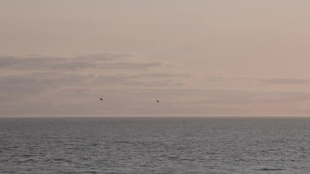 Canadian military helicopters on patrol over the ocean near Sooke, BC, helicopters, sunset, ocean. 4K 24FPS