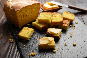 Homemade cornbread slices and butter on kitchen table