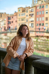 Fototapeta premium Tourist beautiful woman in Girona, Catalonia, Spain near of Barcelona. Famous resort destination in Costa Brava. Portrait of sexy woman posing at the town. Beautiful girl on the empty street in old
