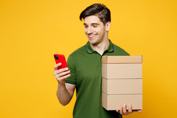 Young smiling caucasian happy man he wears green t-shirt casual clothes hold stack cardboard blank...