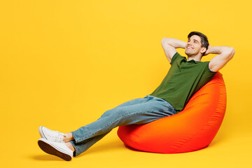 Full body side view young fun happy man he wears green t-shirt casual clothes sit in bag chair hold...