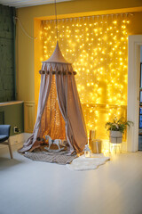 Beautiful canopy and children's toys with luminous garlands. Festive mood in nursery, cozy place © natalialeb