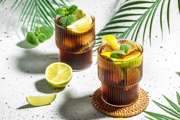 Cuba Libre or long island iced cocktail on a light background, cookbook recipe top view