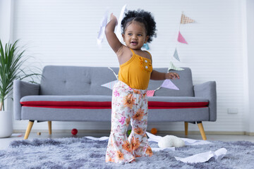 A cute curly hair girl  toddler's naughty play inside the living room.