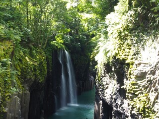 Takachiho Gorge, a narrow chasm cut through the rock by the Gokase River and partway along the gorge is the 17 meter high Manainotaki waterfall cascading down to the river below