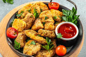 Chicken nuggets and ketchup sauce on a dark background. Food recipe background. Close up