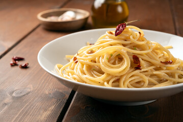 Piatto di saporiti spaghetti con aglio, olio e peperoncino, ricetta tradizionale di pasta italiana,...