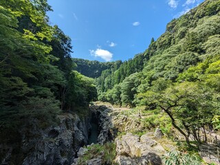 Takachiho Gorge, a narrow chasm cut through the rock by the Gokase River and partway along the gorge is the 17 meter high Manainotaki waterfall cascading down to the river below
