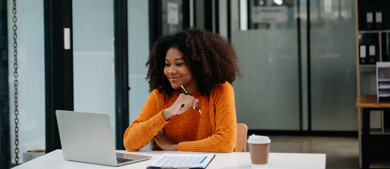 Successful Businesswoman Analyzing Finance on Tablet and Laptop at Office Desk tax, report,...