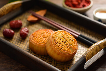 The Mid-Autumn Festival moon cake on the retro background. The Chinese meaning of the moon cake in the picture is: fine five kernels, black sesame, representing the taste of mooncakes