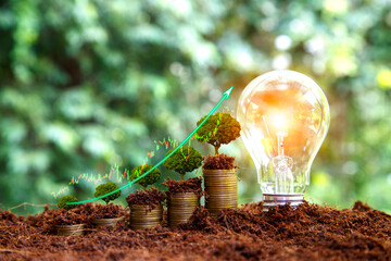 Green energy invest instead gold coins growing. light bulb on green nature background green energy...