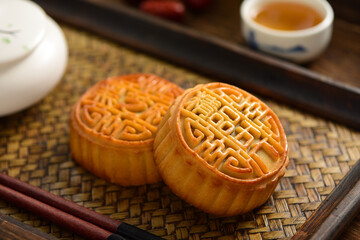 The Mid-Autumn Festival moon cake on the retro background. The Chinese meaning of the moon cake in the picture is: fine five kernels, black sesame, representing the taste of mooncakes