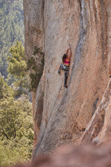 Faceless alpinist climbing rocky mountain