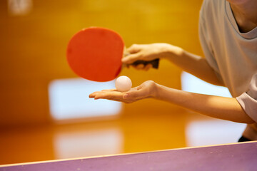 体育館にて卓球の練習をするスポーツウェアを着た日本人女性