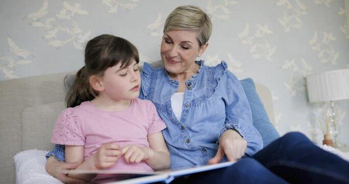Mother and daughter reading together picture book