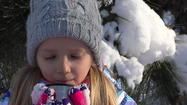 Kid Drinking Hot Tea in Thermos in Cold Winter, Tourist Child Warming, Girl at Sledding Skiing Resort, Sledging in Mountains