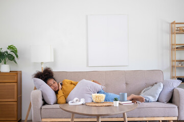 Young woman relishes film watching on living room couch.