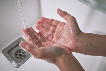 Anonymous kid washing hands with soap