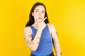 Beautiful woman wearing blue tank top Thinking worried about a question, concerned and nervous with hand on chin.