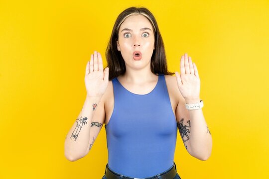 Beautiful woman wearing blue tank top Moving away hands palms showing refusal and denial with afraid and disgusting expression. Stop and forbidden.