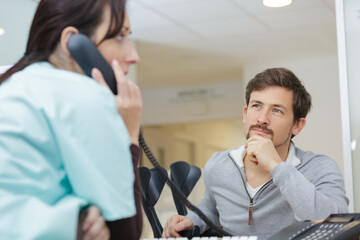 receptionist and doctor with client in hospital