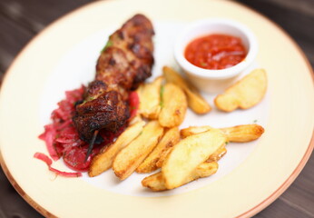 Dish of kebabs on skewer of potatoes and salad with sauce. Cooking at home concept