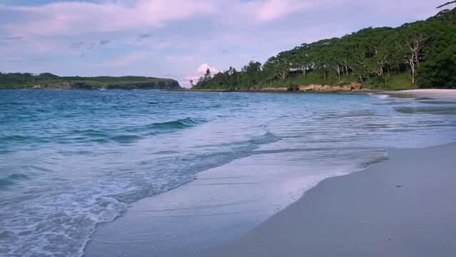 4k Video – Beautiful and remote Murrays Beach with calm waves, pristine clear waters and pearly white sand at sunset in Booderee National Park, Jervis Bay Territory, NSW, Australia. 