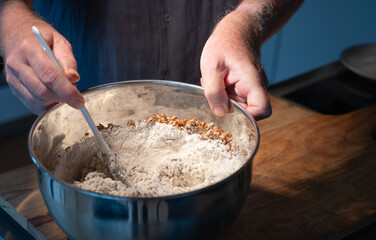 Dough preparation for a rustic grain bread. Mixing ingredients in a bowl. - 644848613