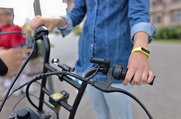 Man holds handlebars of black bicycle in street. Cycling for health and as a lifestyle concept