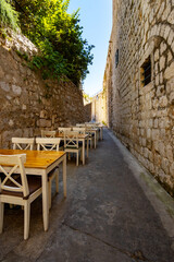 Fototapeta na wymiar open-air cafe on the narrow street of the old town of Dubrovnik, croatia, vintage architecture, the concept of traveling through the Balkans