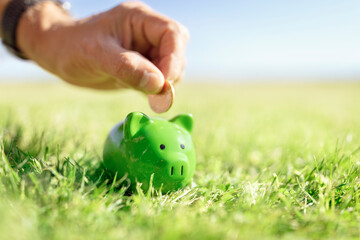 Saving money in green piggy bank, savings, accounting, banking and business account or sustainable...