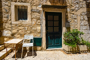 Fototapeta na wymiar table and chair at entrance to the old house, street view of the old town Dubrovnik, Croatia, medieval European architecture, narrow streets in historic city